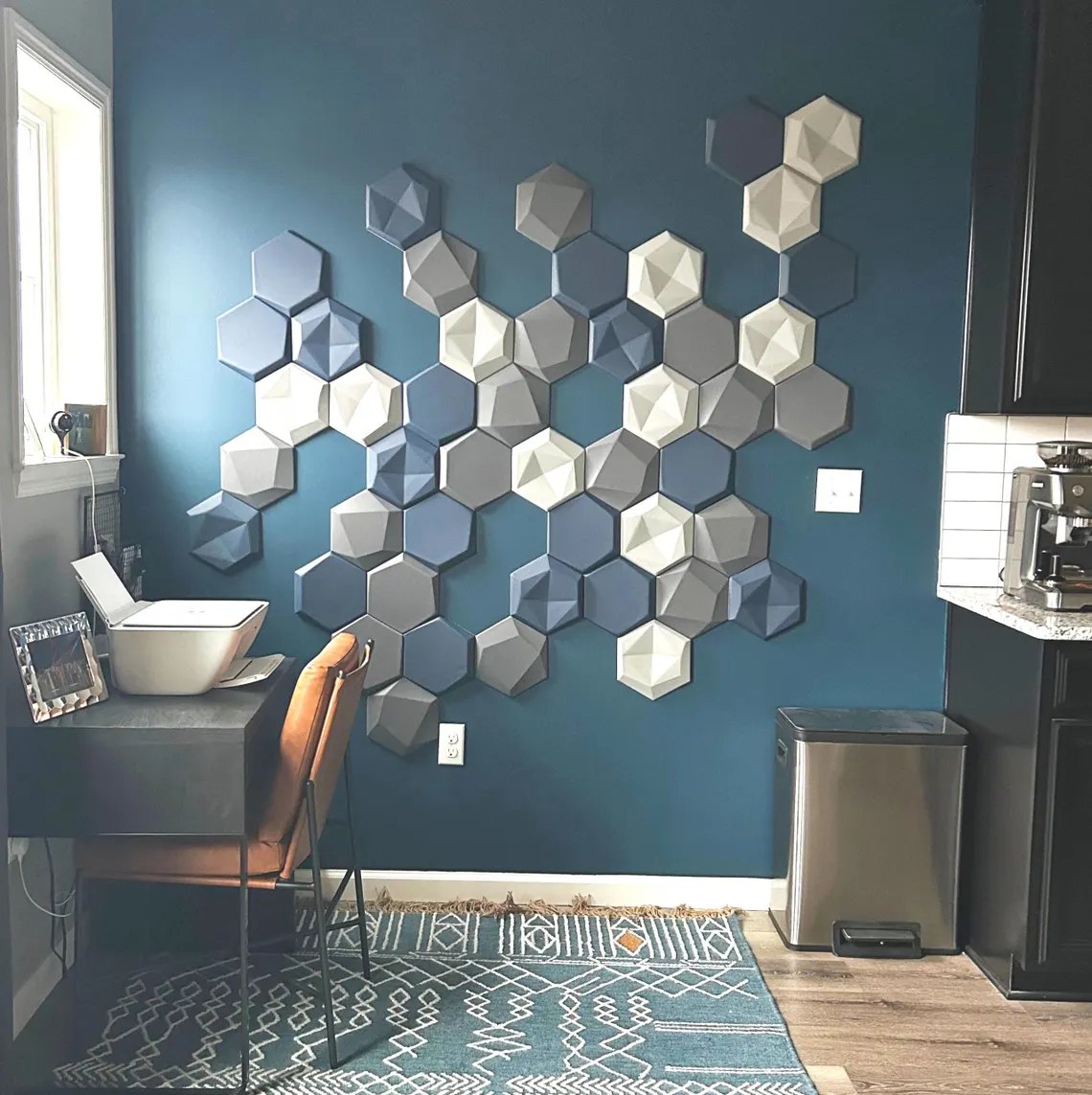 Home-Office mit Hexagon-Wandpaneelen auf blauer Wand
